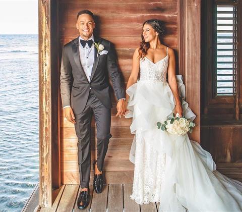 Couple in wedding attire in a bungalow on the water